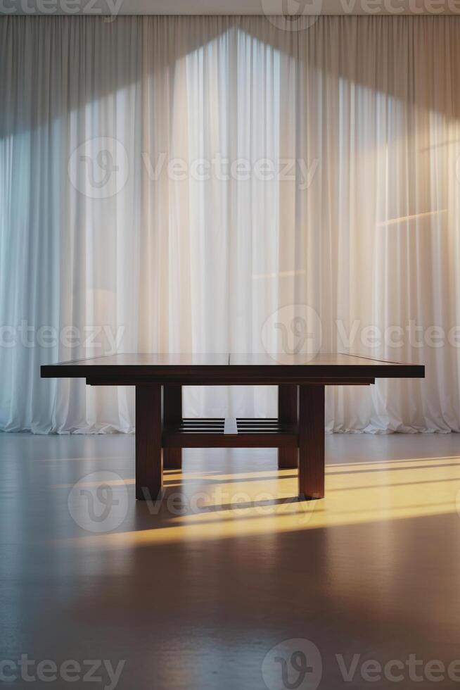 Modern wooden table illuminated by warm sunlight in a minimalist interior space with sheer curtains photo
