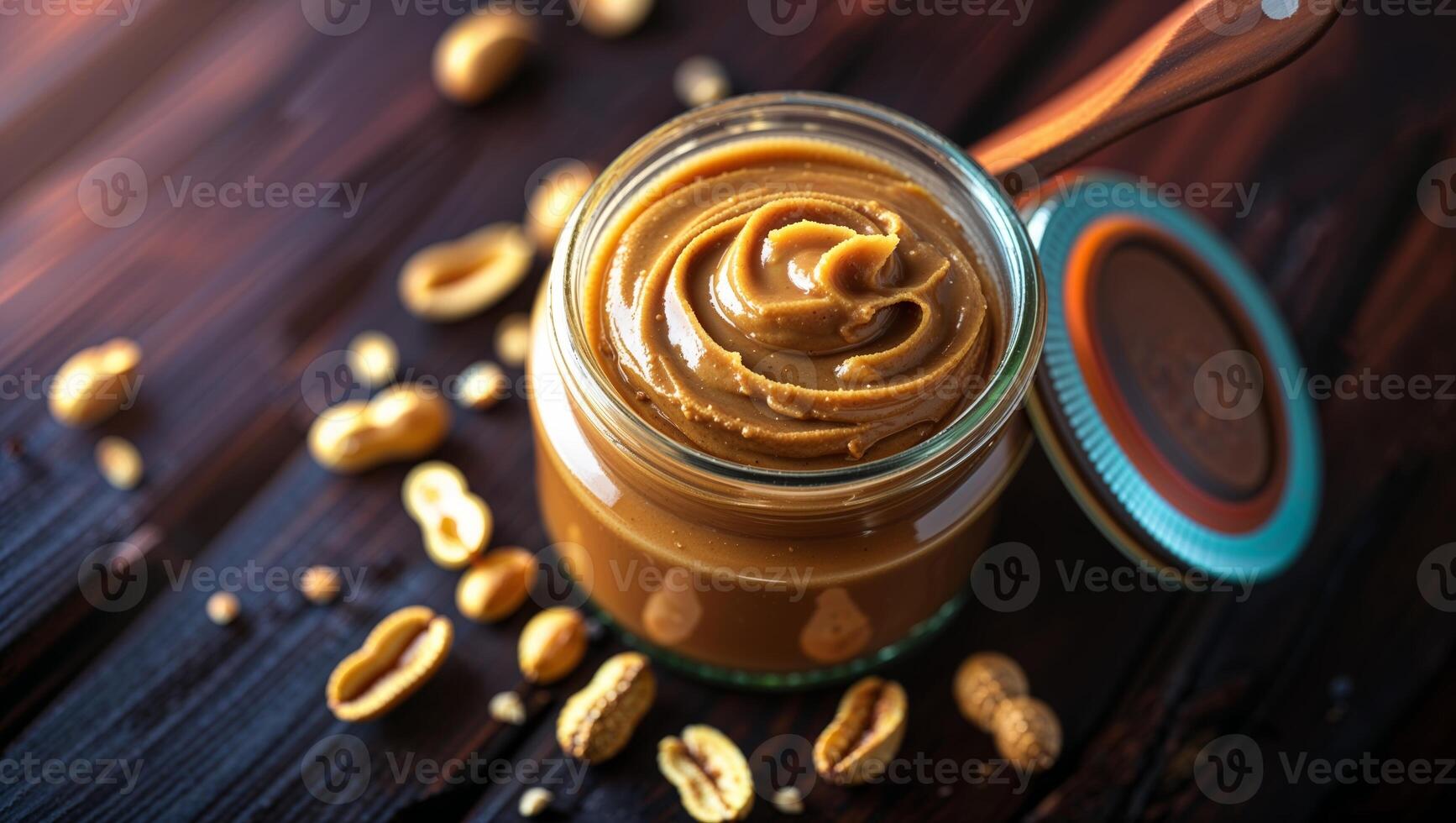 Natural nut butter in a jar surrounded by scattered peanuts on a wooden table in a cozy kitchen setting during the afternoon light photo