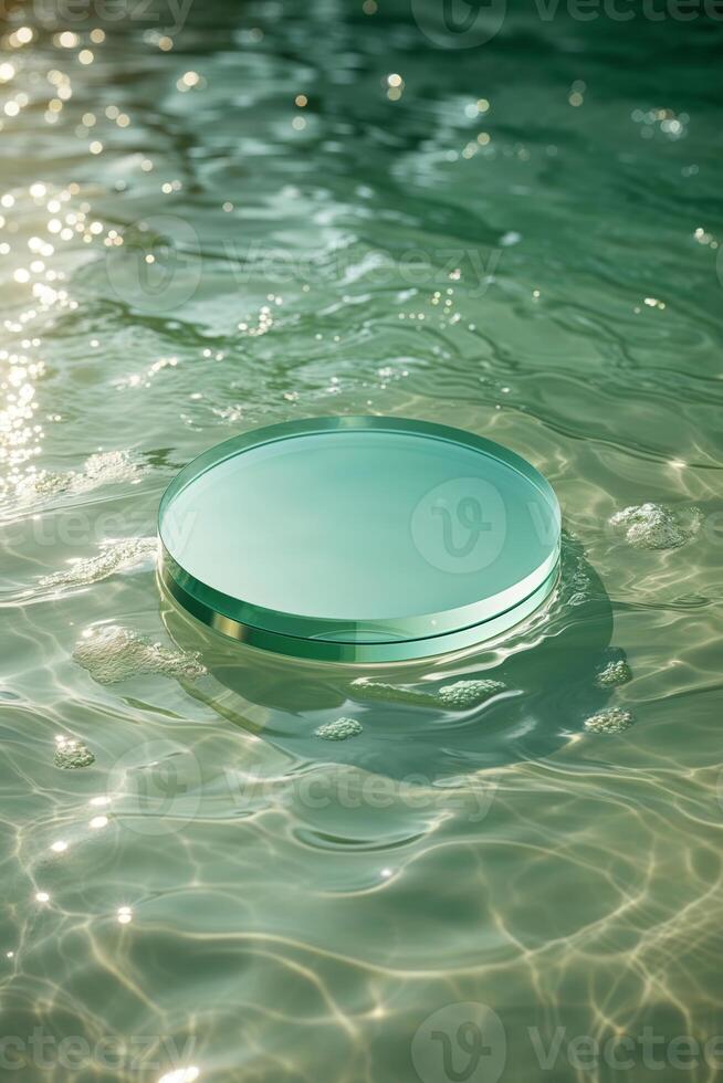 Circular glass object floats peacefully on the surface of a tranquil swimming pool in bright sunlight photo