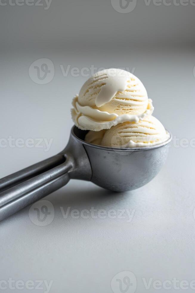 Two scoops of creamy vanilla ice cream served in a metal ice cream scoop on a light background photo