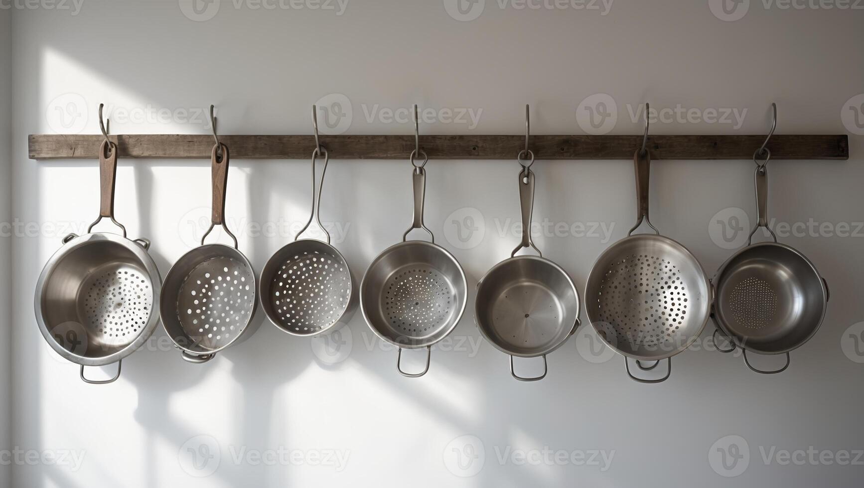 Kitchen tools hanging on a wooden rack with sunlight casting shadows in a modern cooking space photo