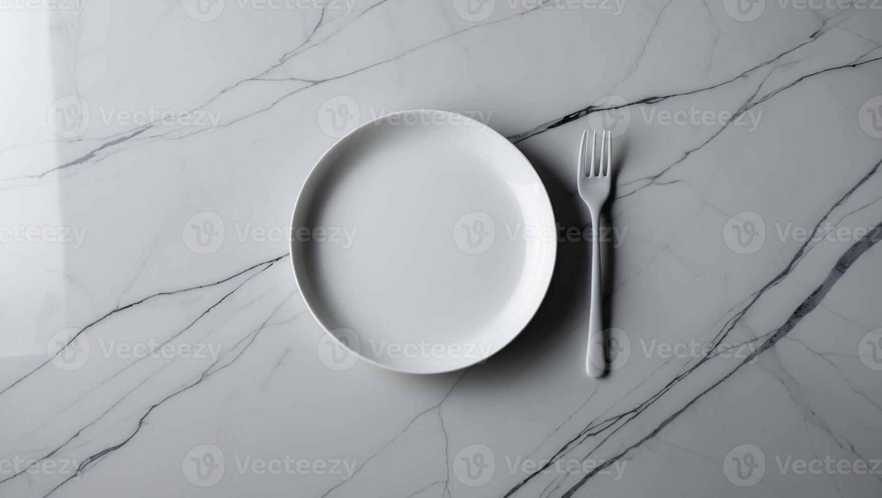 Simple white plate and fork arranged on a marble table surface in a modern dining setting photo