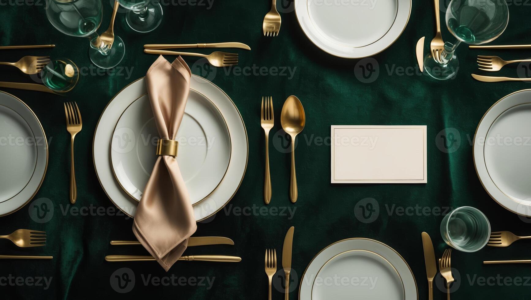 Elegant table setting for a formal dinner event featuring gold utensils and fine china on a dark green tablecloth photo