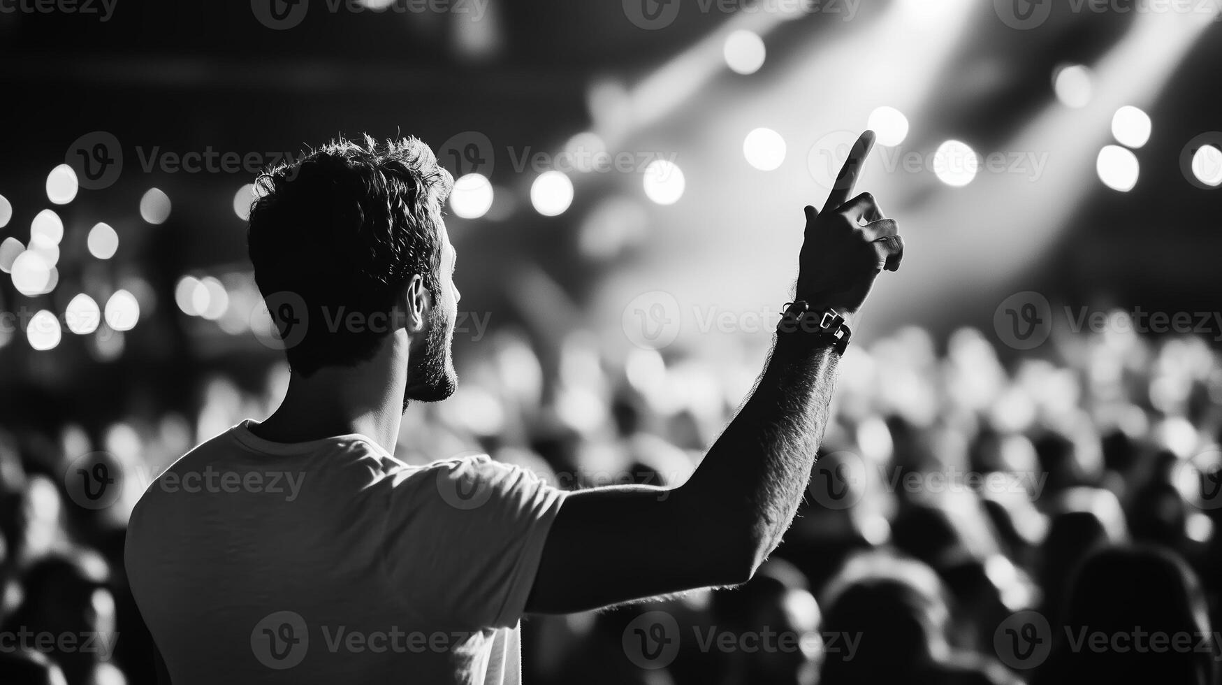 Crowd member raises hand during lively concert at night in an energetic venue filled with lights photo