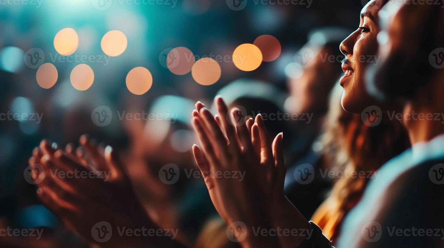 Audience members enthusiastically clapping hands during a live performance at an evening event photo