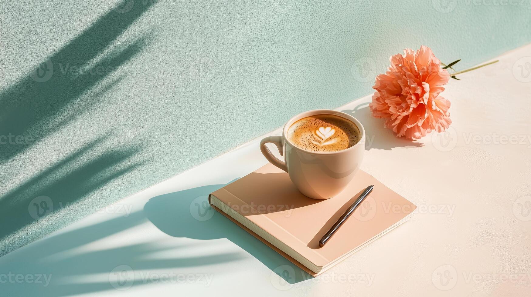 Coffee with latte art, a notebook, and a flower create a serene workspace during an afternoon break photo