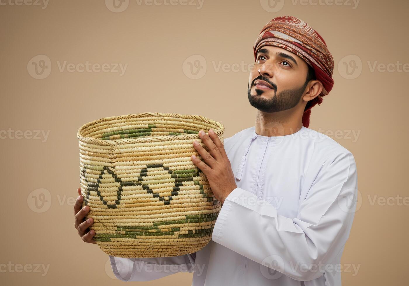 Omani Man Holding Traditional Woven Basket Looking Upward Thoughtfully photo
