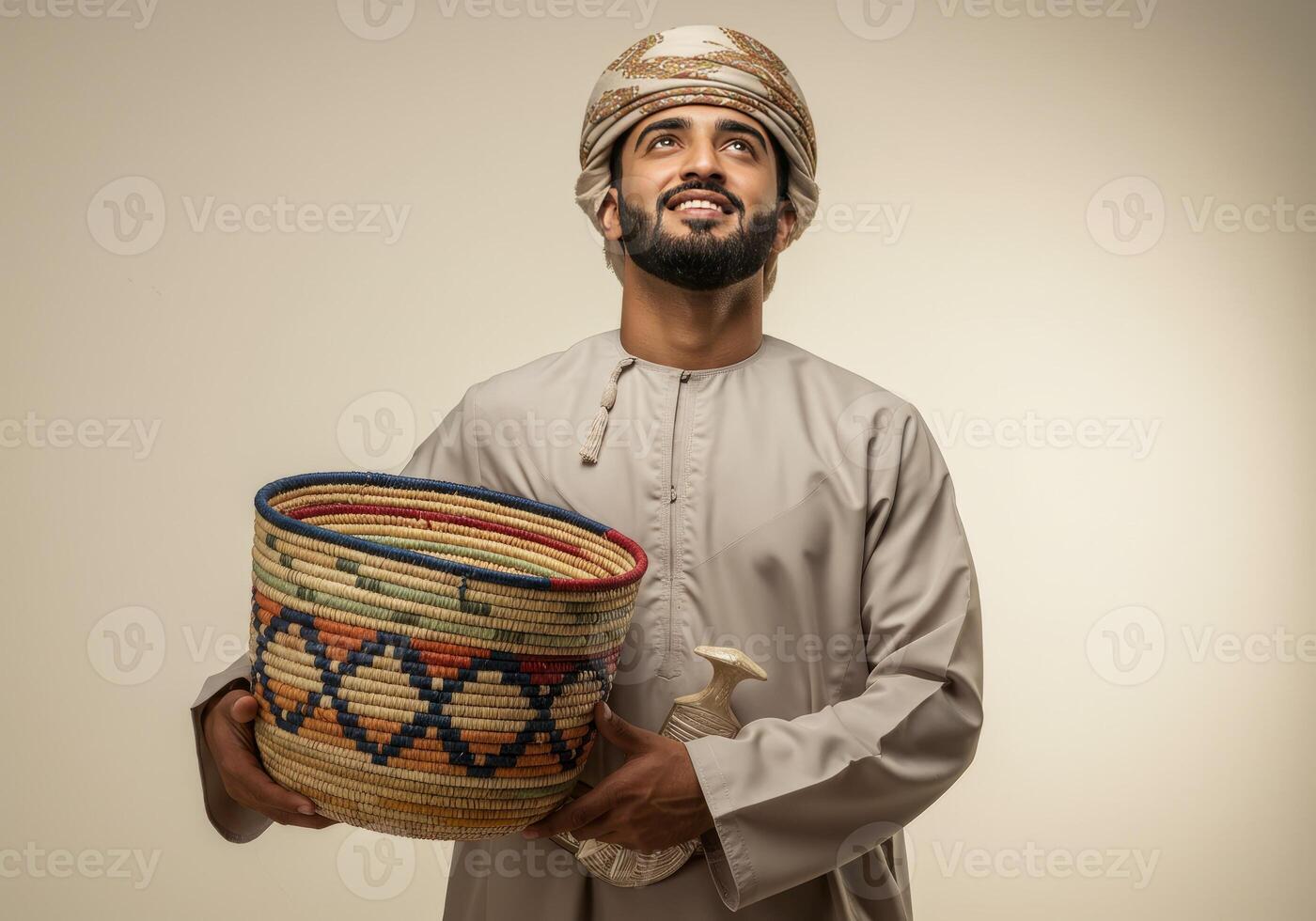 Man Holding Basket and Jambiya While Looking Up in Traditional Omani Dress photo