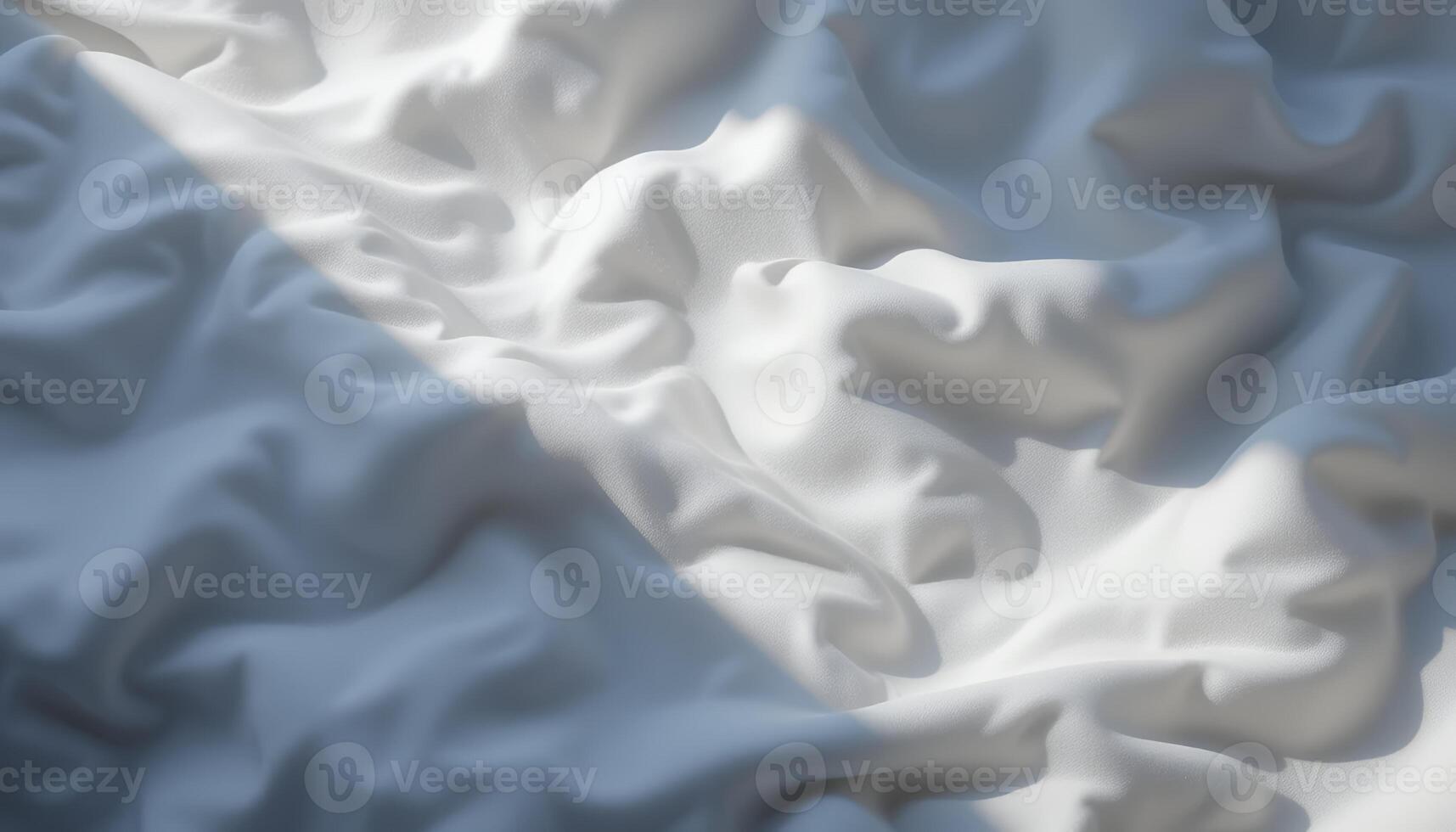 White fabric with soft folds and a strong beam of light creating shadows photo