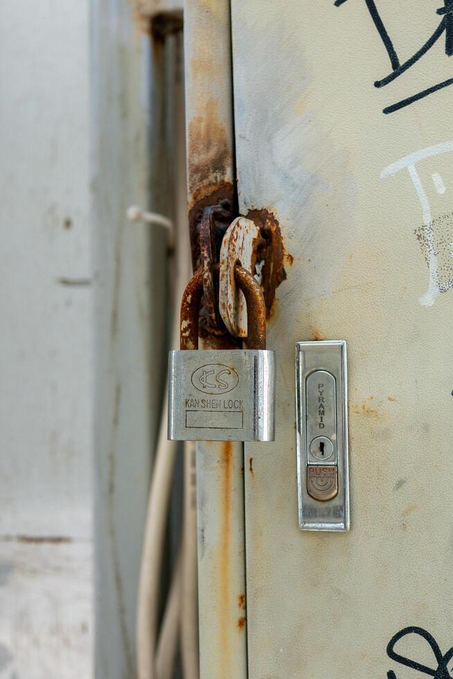 March 08, 2025, Semarang, Indonesia, close up of keys and padlocks installed on an electrical panel photo
