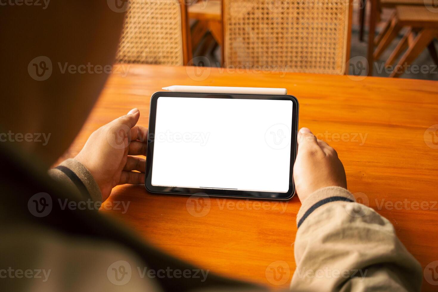 Hands holding a tablet with an empty white screen, perfect for digital design or app presentation. photo