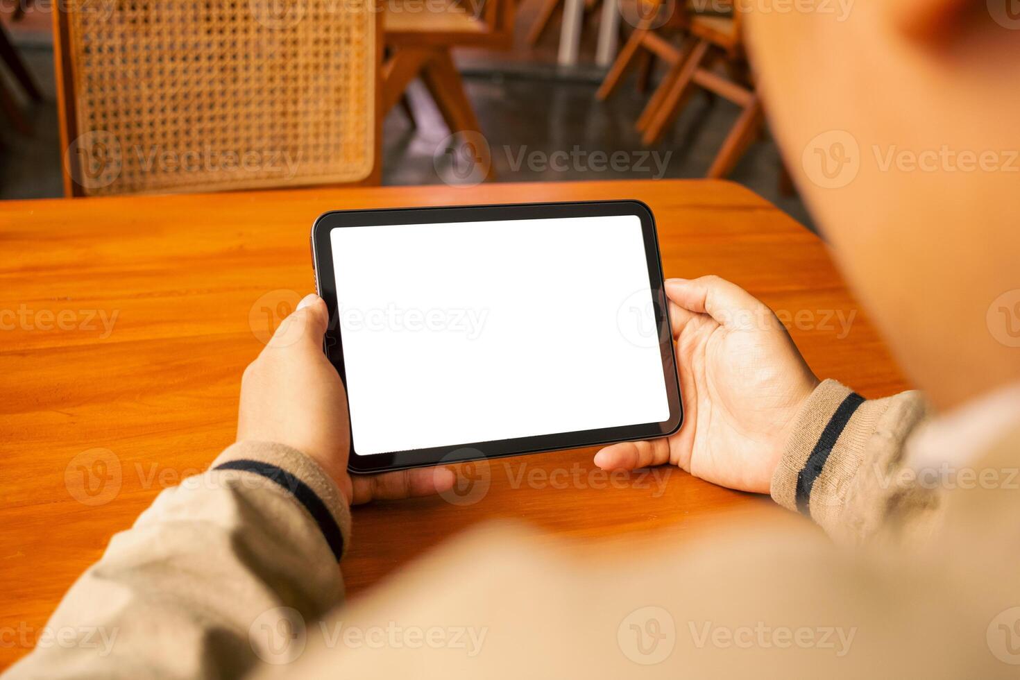Man using a tablet with a blank screen, placed on a wooden table with a stylus, great for design photo