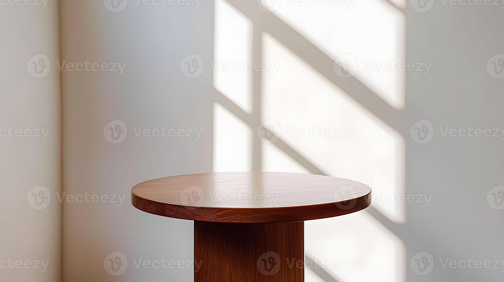 Sunlight illuminates a simple, round wooden side table against a white wall. photo