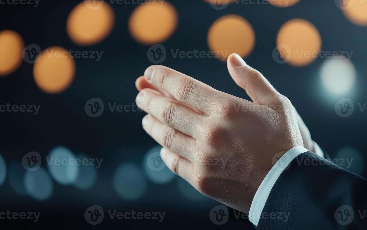Clapping hands in formal setting, expressing appreciation and support. blurred background adds sense of depth and focus on gesture photo