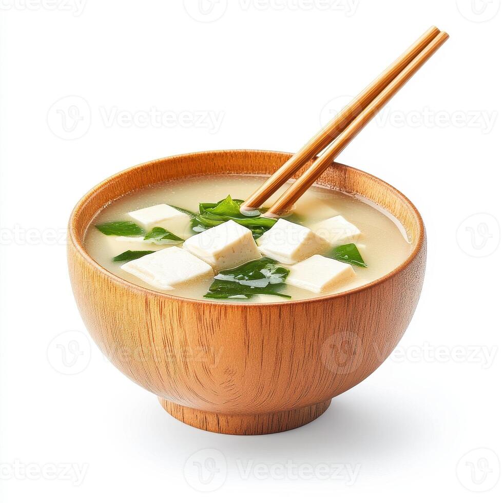 bowl of hot miso soup with tofu and seaweed, garnished with fresh herbs, served with chopsticks. This comforting dish is perfect for cozy meal photo