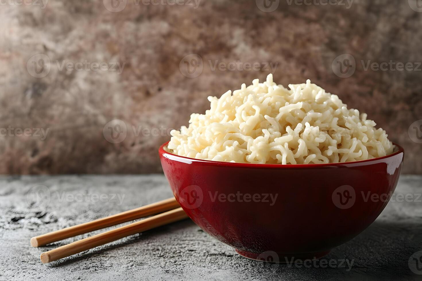 Cooked noodles in a red bowl with chopsticks. photo