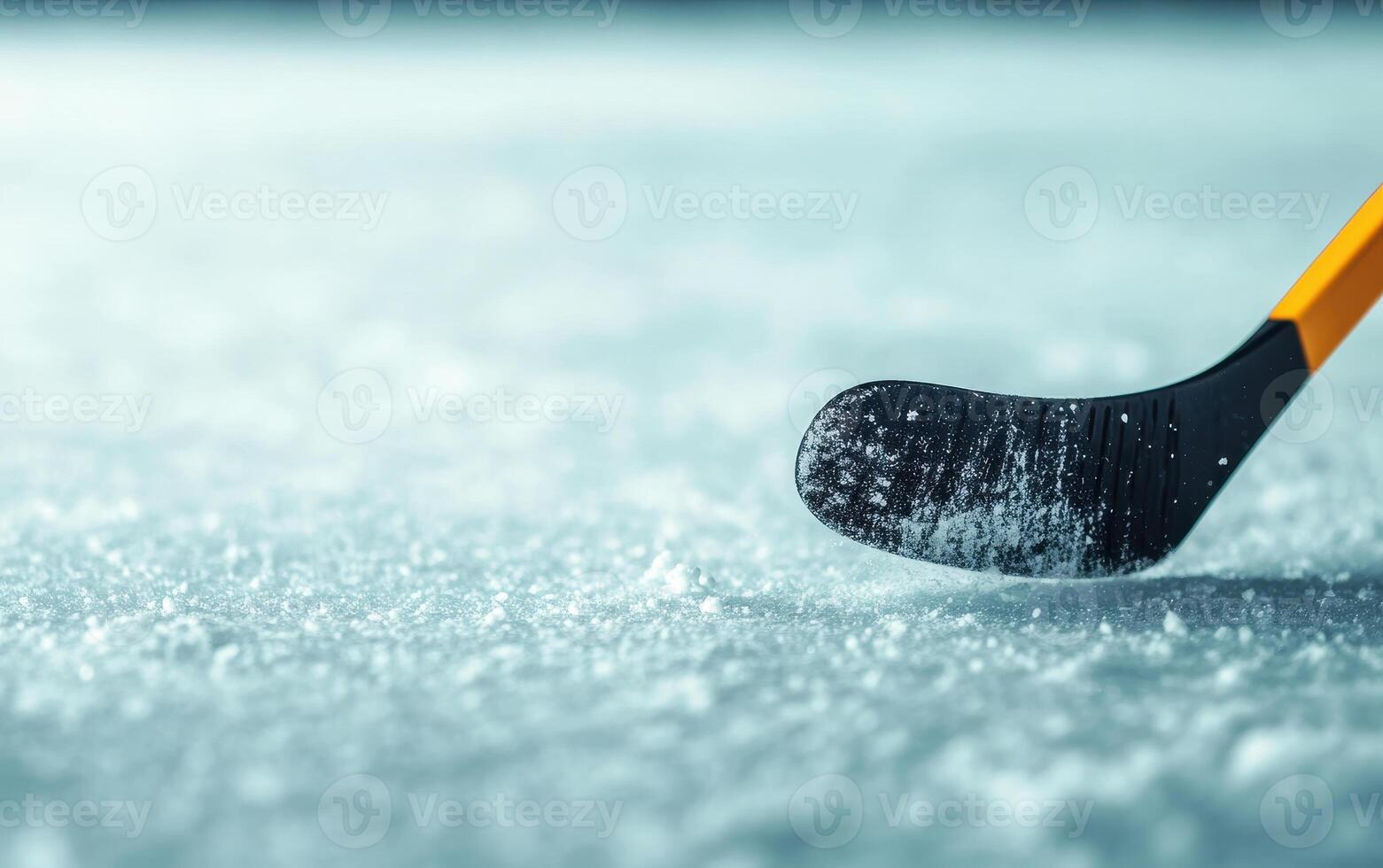 close up of ice hockey stick poised to hit puck on frozen surface, showcasing texture of ice and stick blade. scene captures excitement of game photo