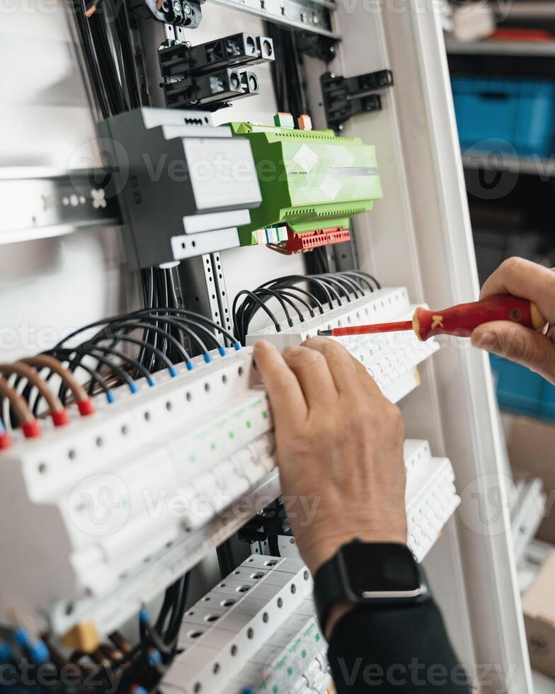 smart home, connecting wires in the electrical box, close-up of a wire with pliers photo