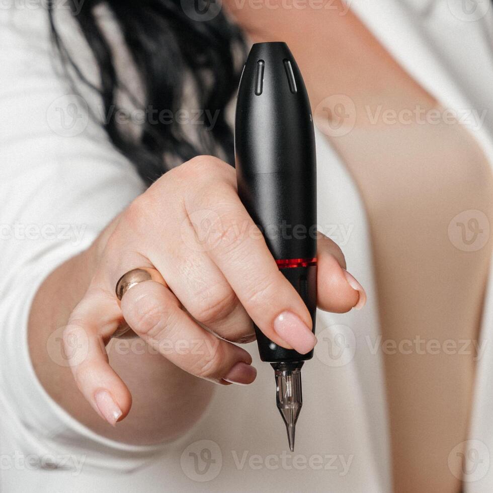 permanent makeup machine in the hands of a master photo