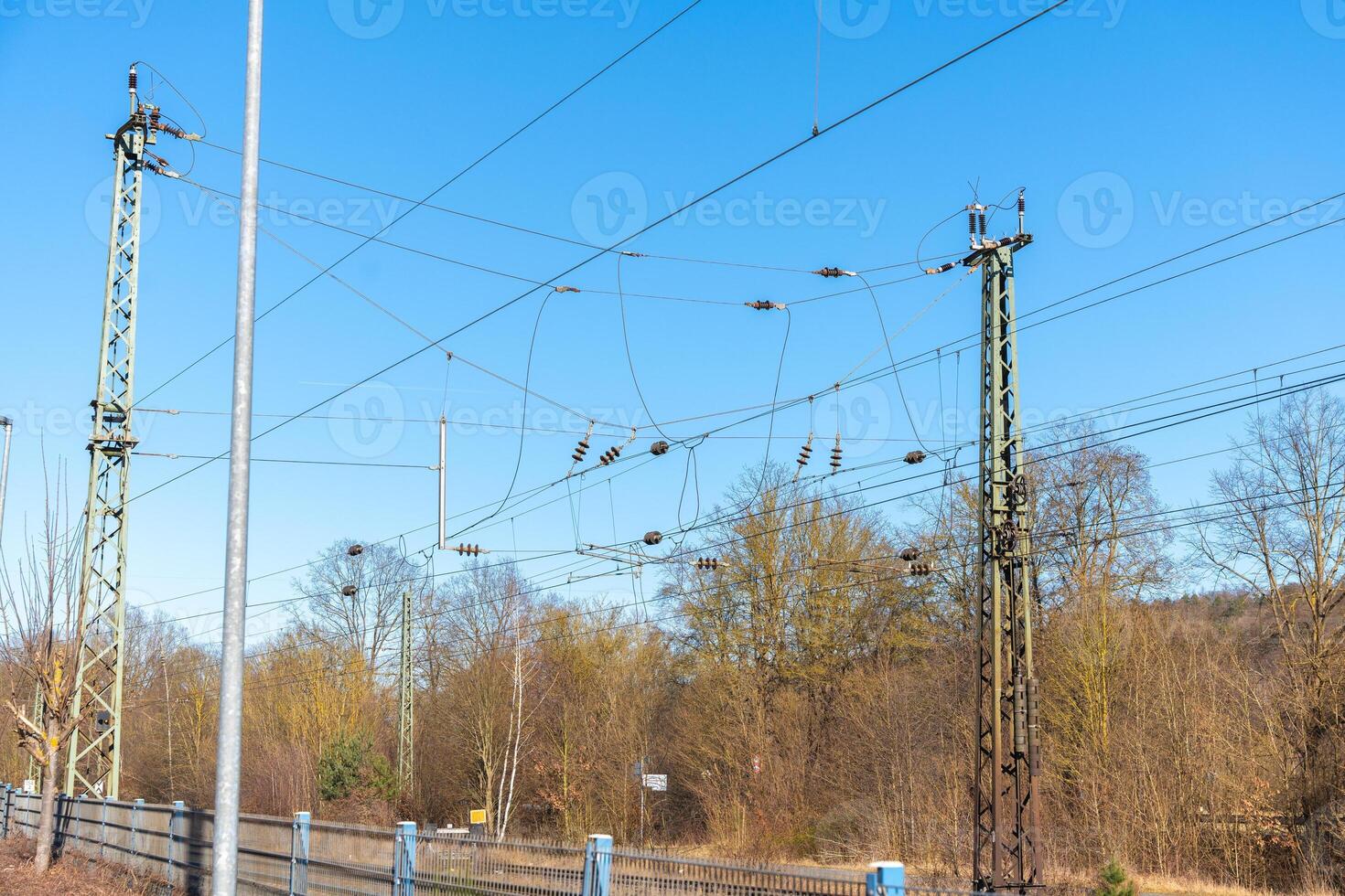 The scene depicts a series of electronic wires stretched along a railroad, tangled together on a sunny day, capturing both the beauty and the complexity of industrial life. photo