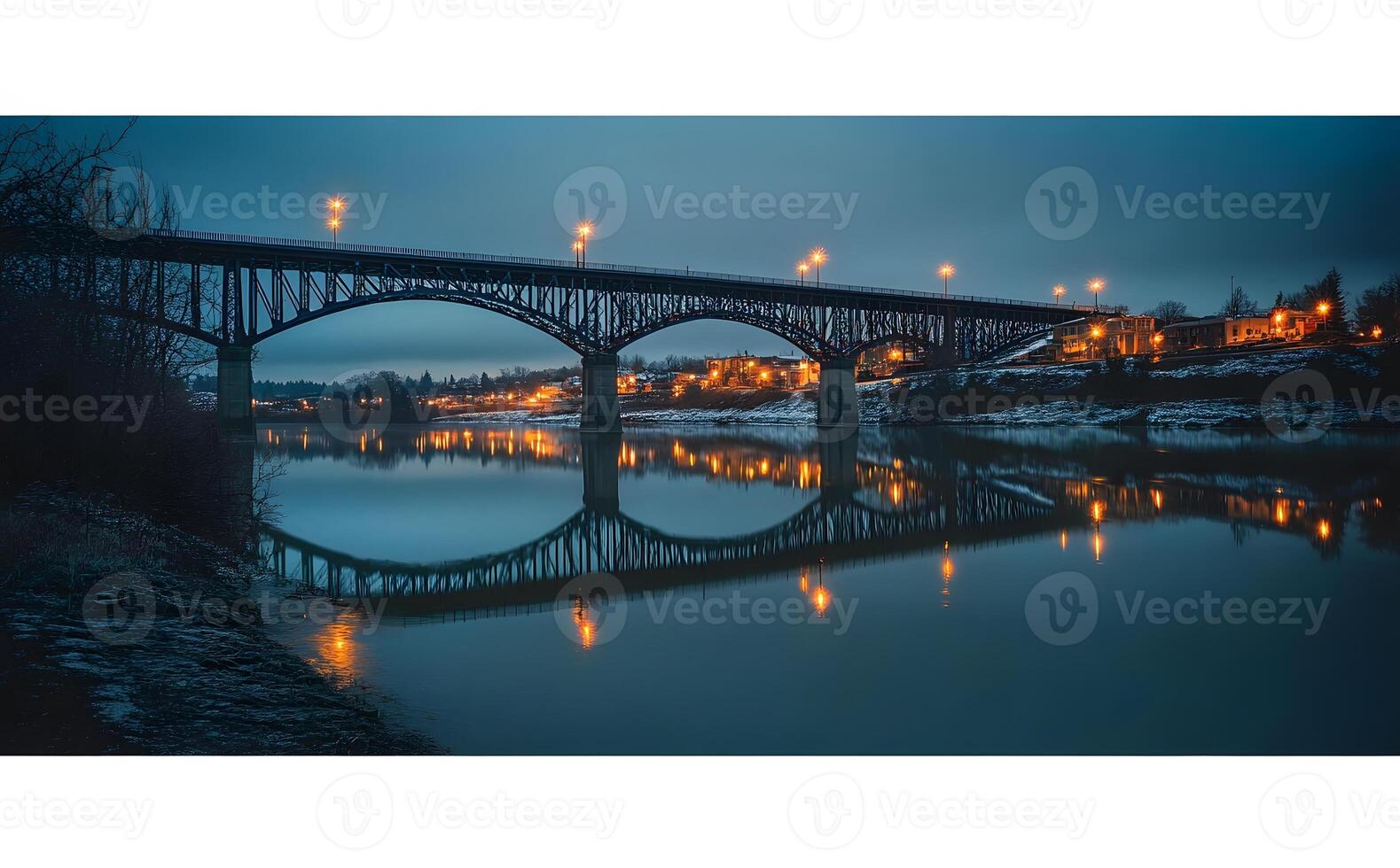 Illuminated Bridge Reflecting in Calm River Water at Dusk photo