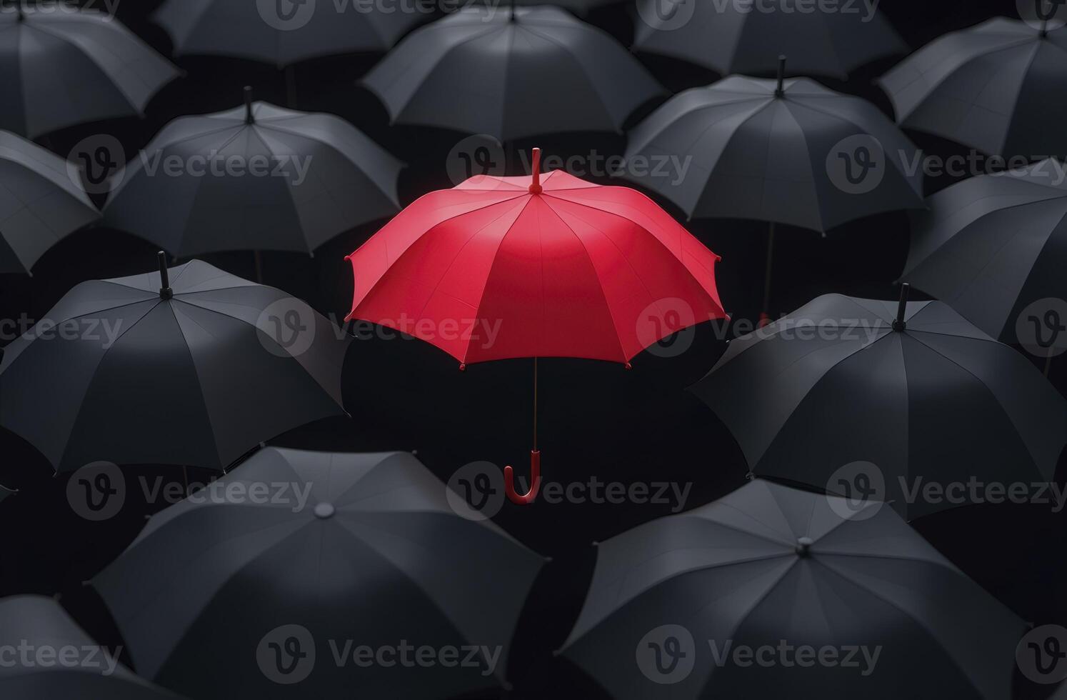 Red umbrella standing out from crowd of black umbrellas symbolizing uniqueness and individuality. photo