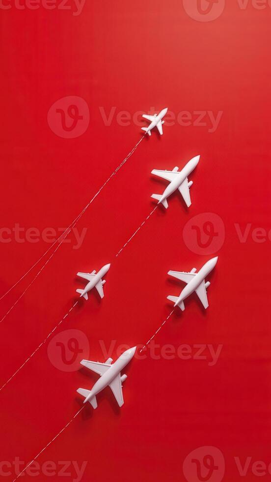White airplane models flying in formation on red background photo