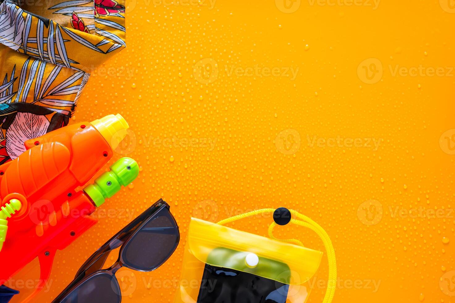 Colorful shirt with water gun, waterproof case for smartphone and sunglasses for Songkran Festival celebration in Thailand. photo