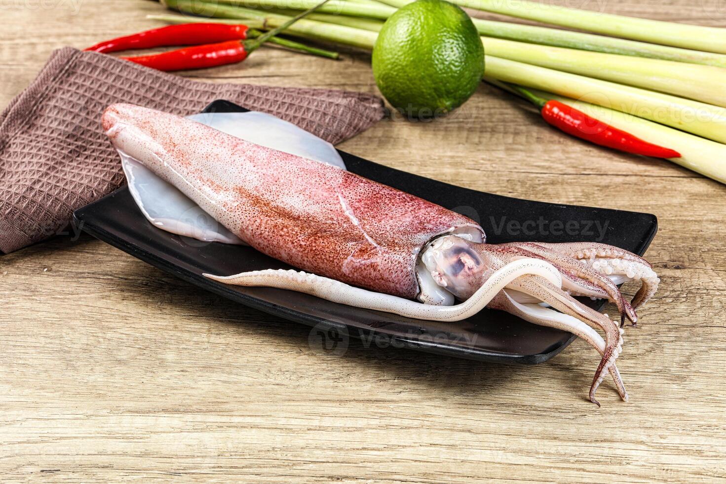 A squid on a plate with a knife and some other vegetables photo