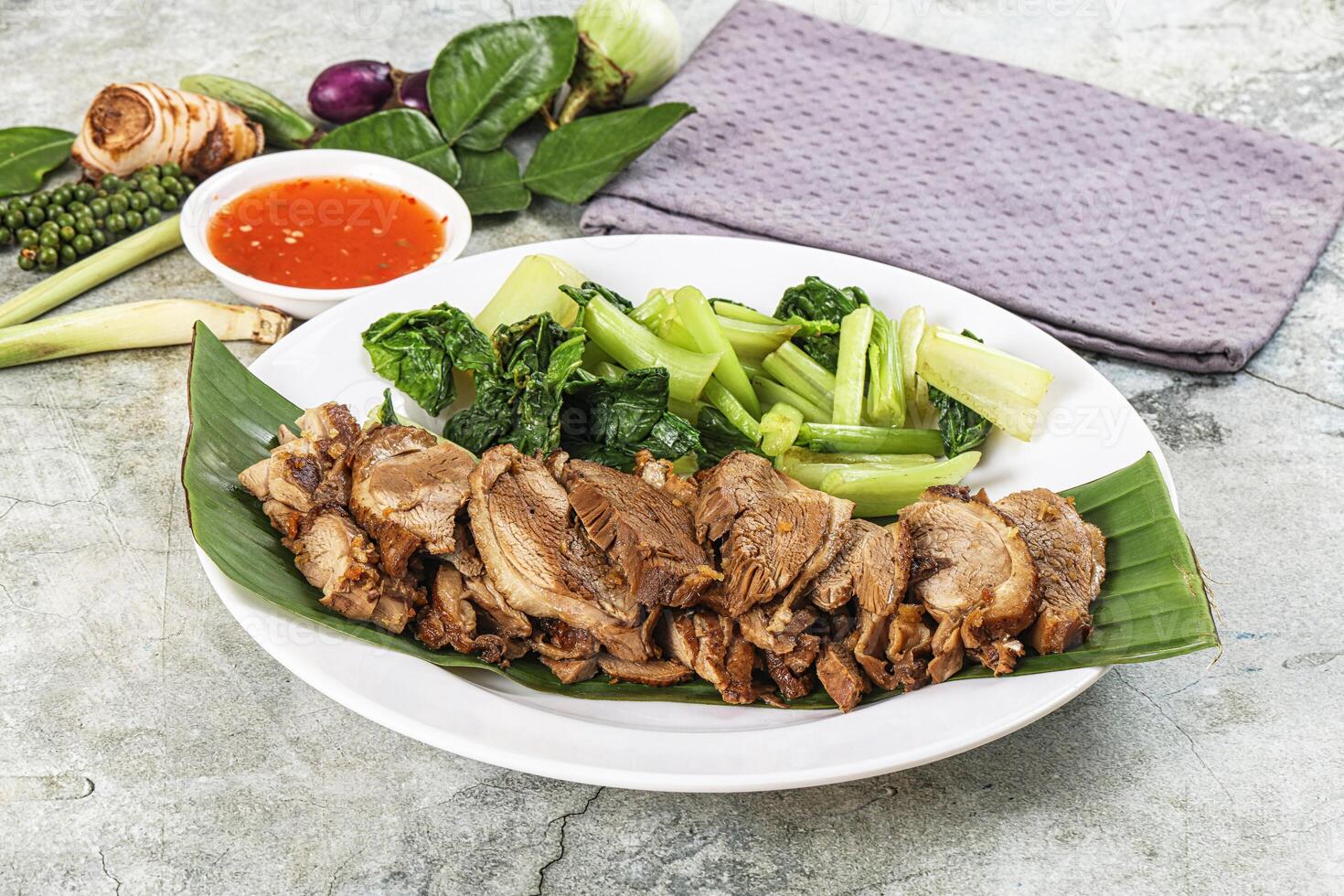 A plate with meat and vegetables on it photo