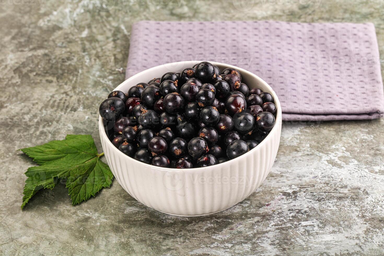 Black currant in a bowl on a table photo