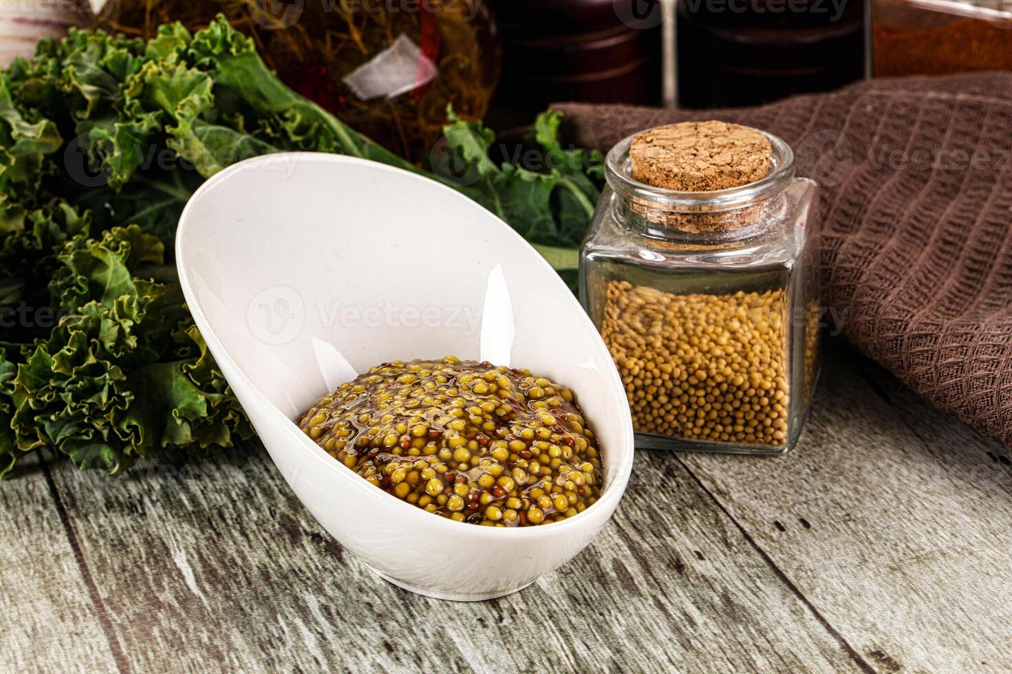 A bowl of mustard and a bottle of mustard photo