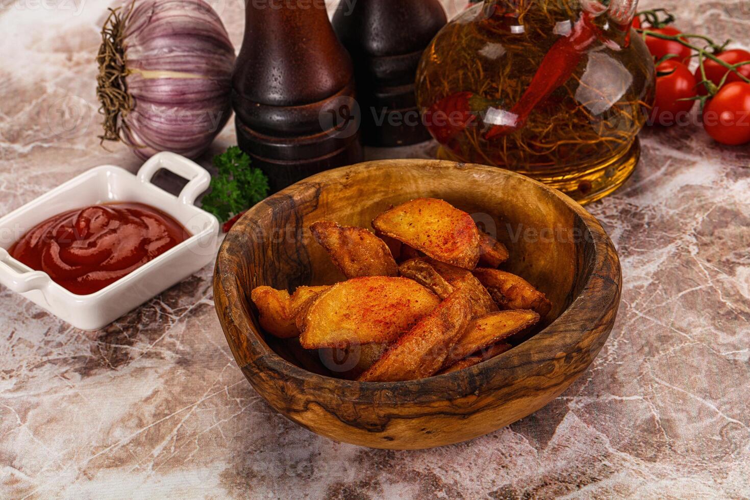 A bowl of potato chips and ketchup on a marble counter photo
