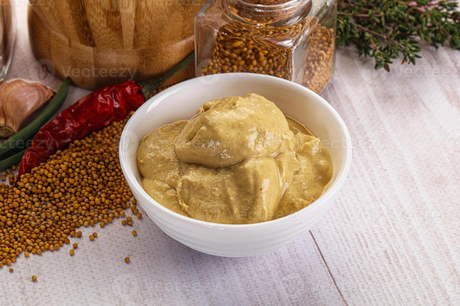 A bowl of mustard and spices on a table photo