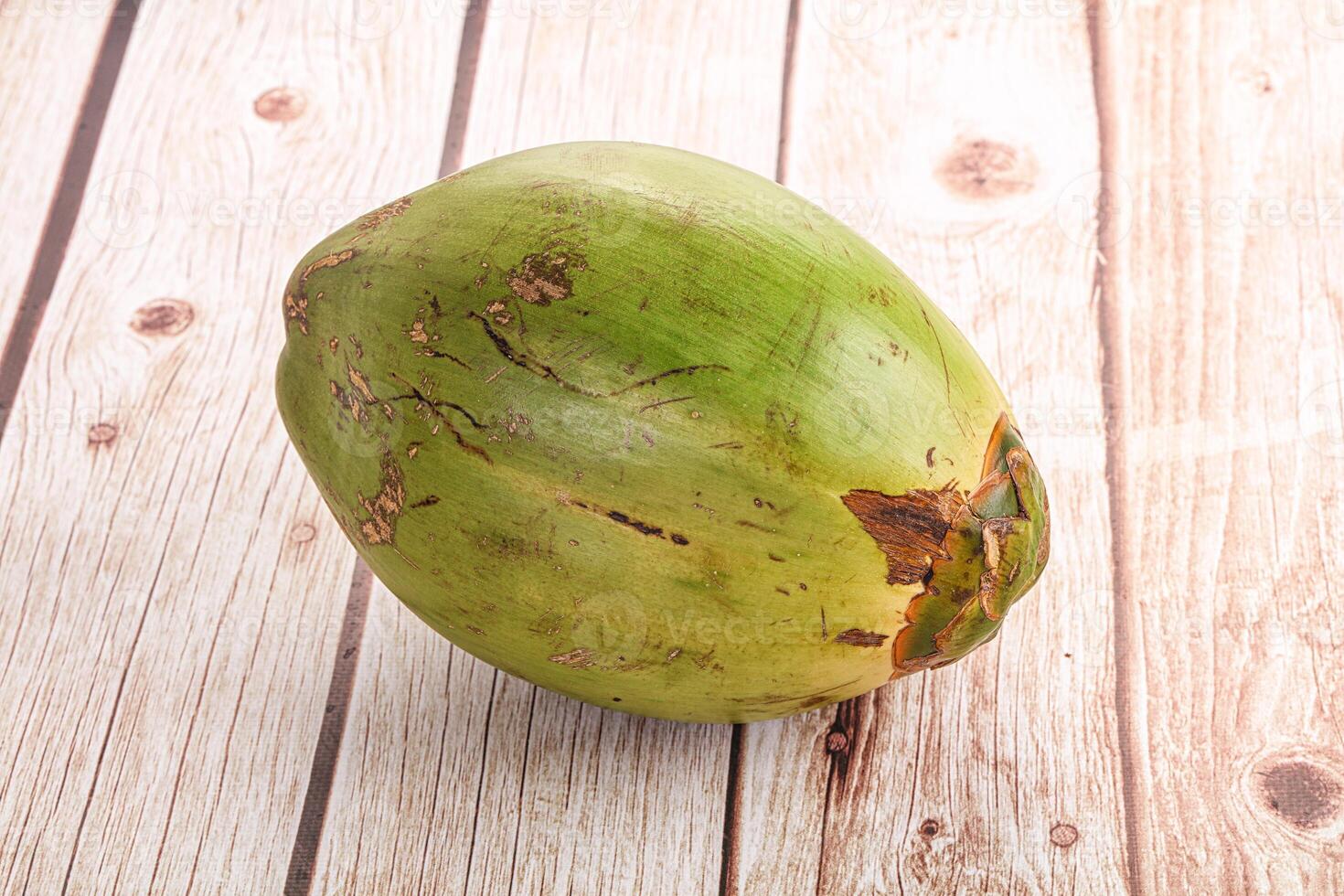 A coconut on a wooden table photo