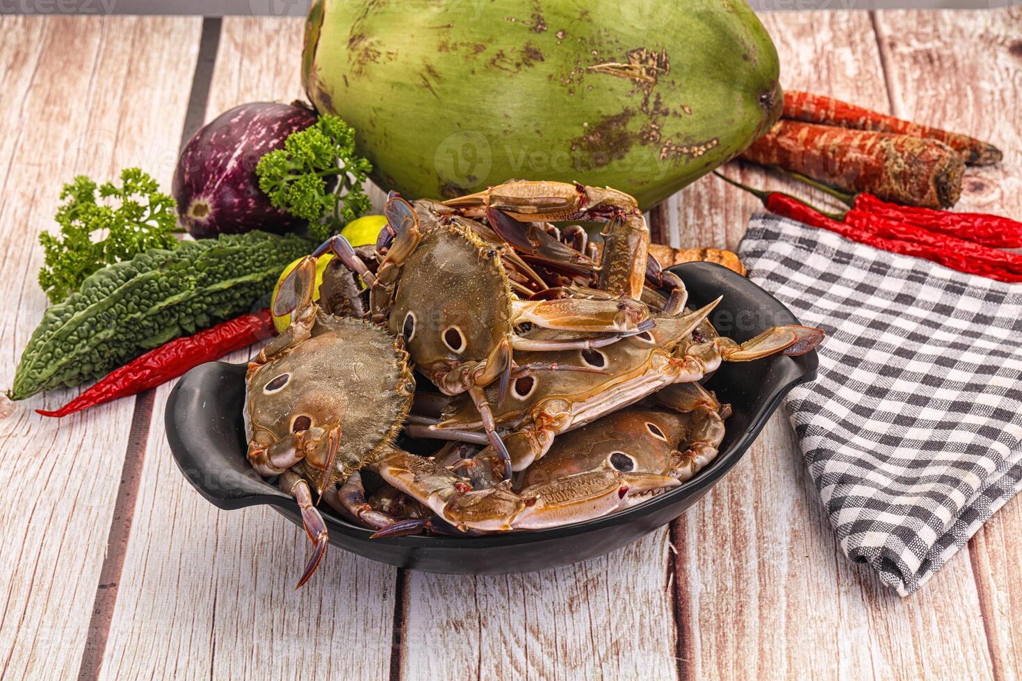 A bowl of crabs and vegetables on a table photo
