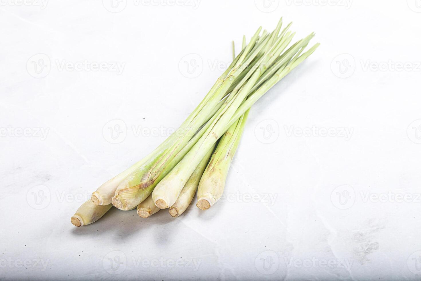 A bunch of green leeks on a white surface photo