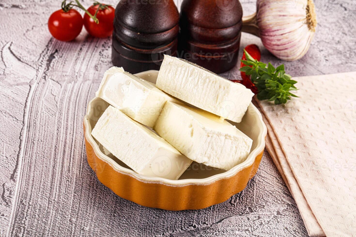 A bowl of cheese and tomatoes on a table photo