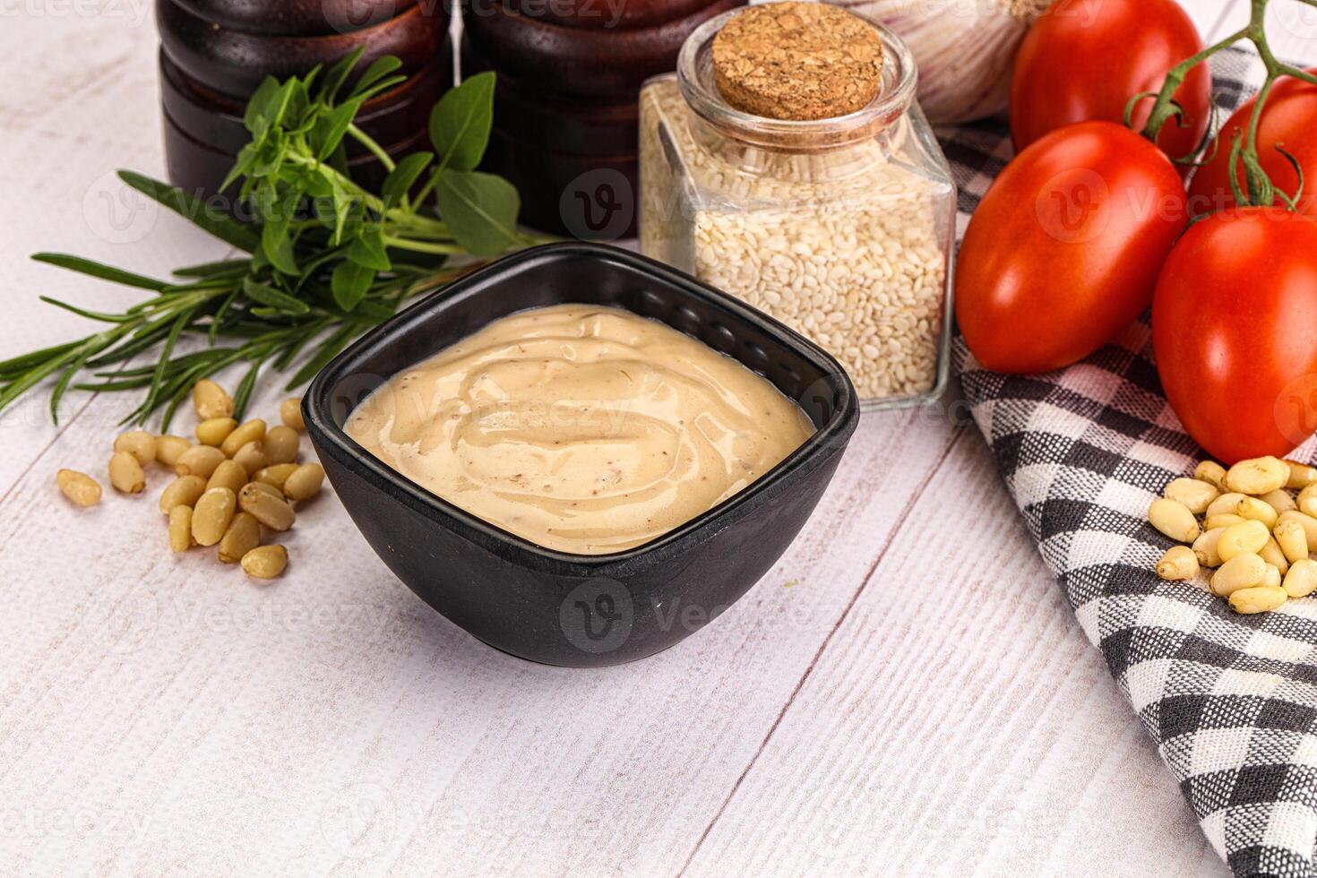 A bowl of peanut butter and a jar of mustard photo