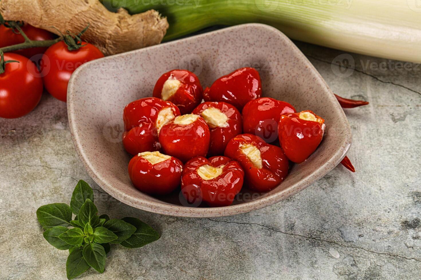 A bowl of red peppers and a bowl of tomatoes photo