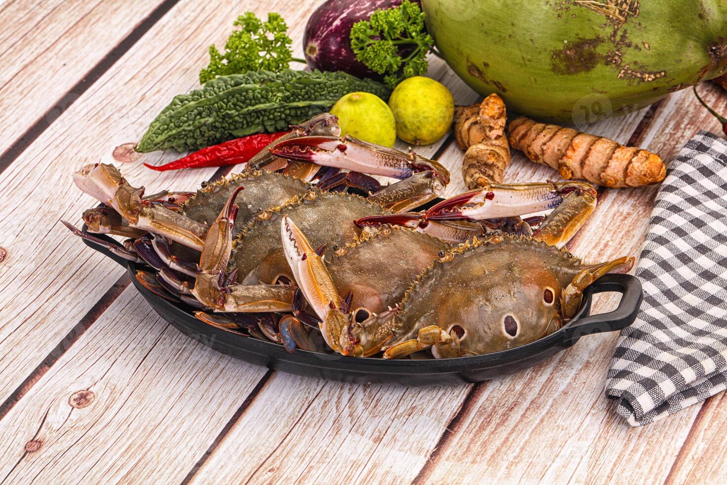 A bunch of crabs and other vegetables on a table photo