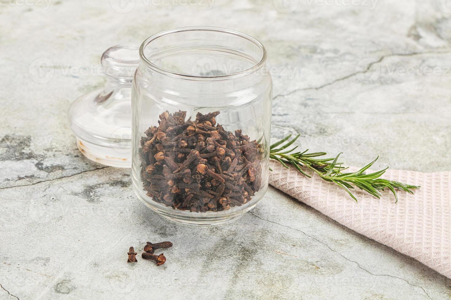 A glass jar with dried herbs and a spoon photo
