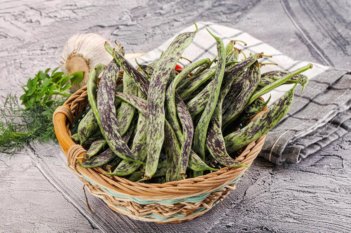 A basket filled with green beans and herbs photo