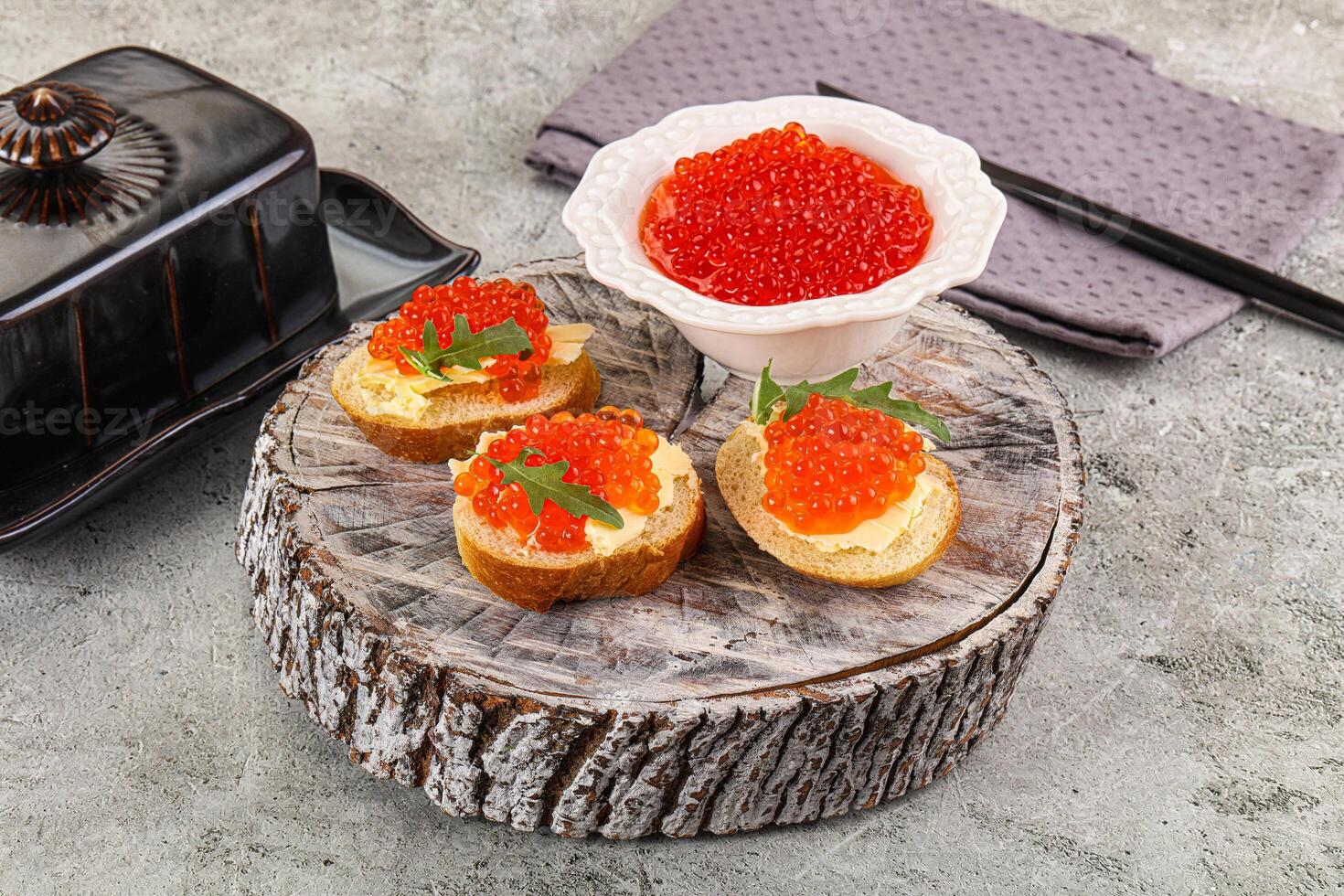 A plate with some food on it and a bowl of red caviar photo