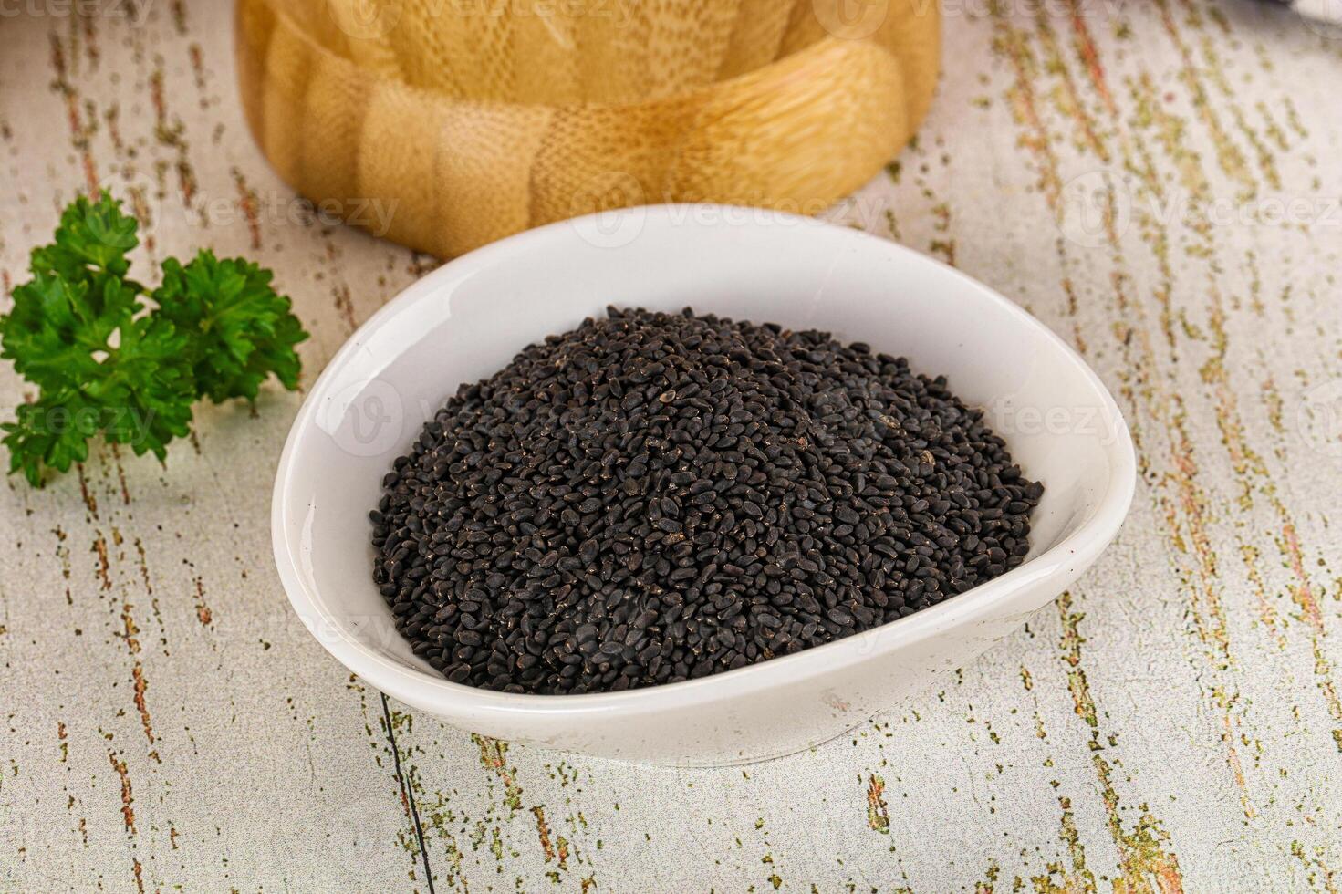 A bowl of black seeds on a table photo