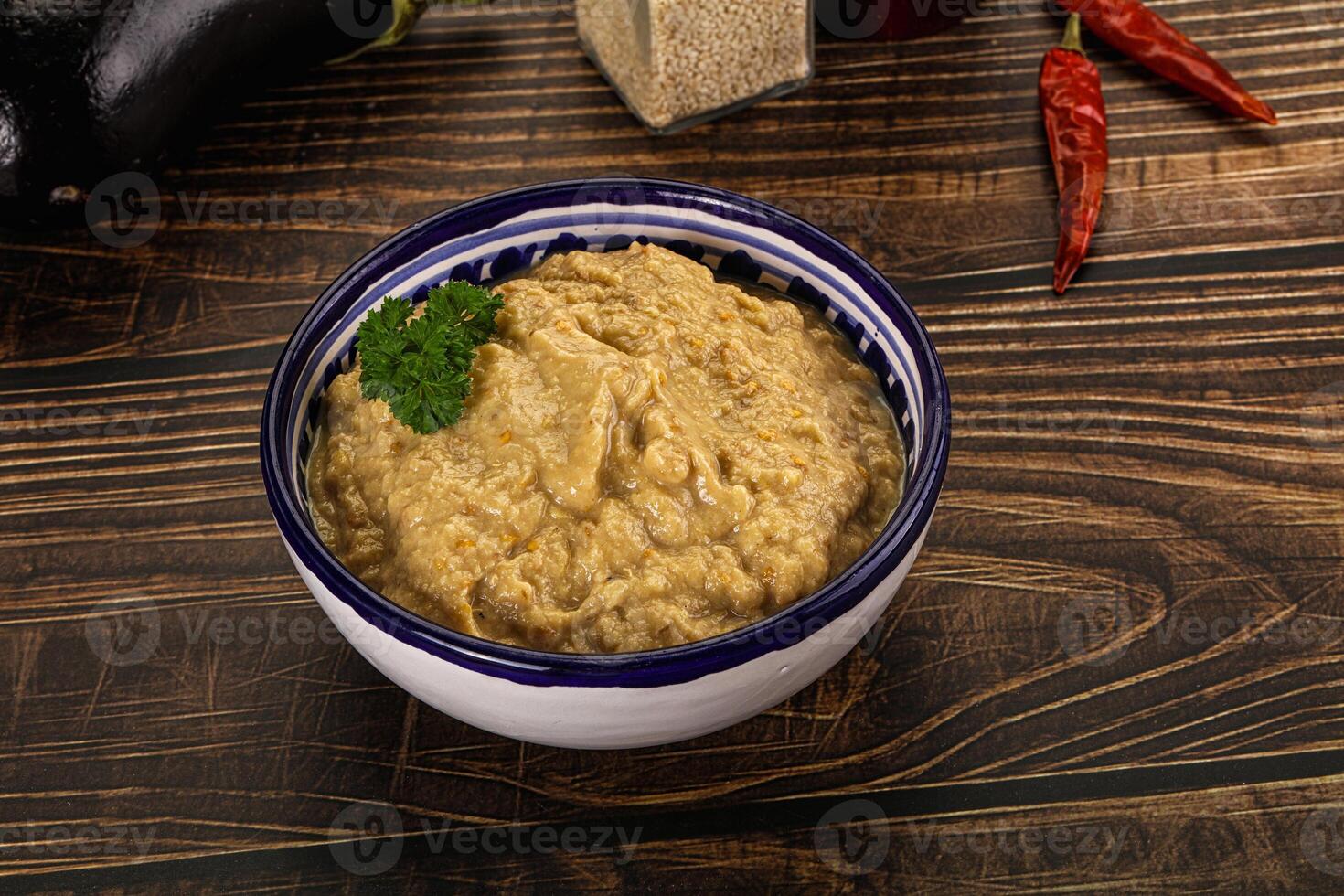 A bowl of hummus with some vegetables and spices photo