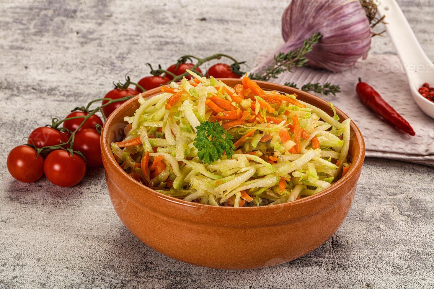 A bowl of coleslaw with carrots and tomatoes photo