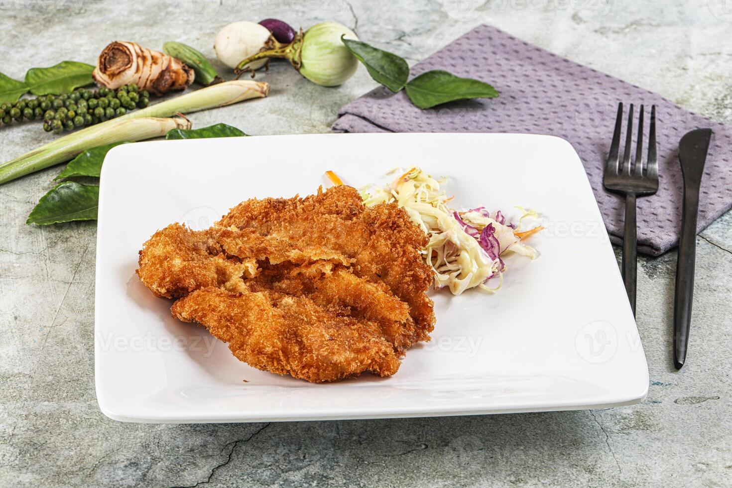Fried chicken with coleslaw and vegetables on a white plate photo