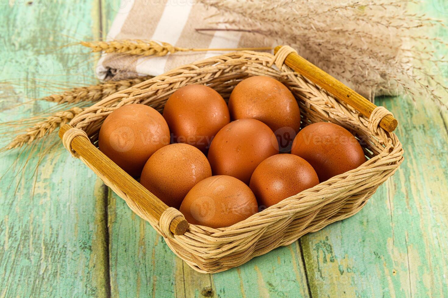 Fresh eggs in basket on wooden table photo