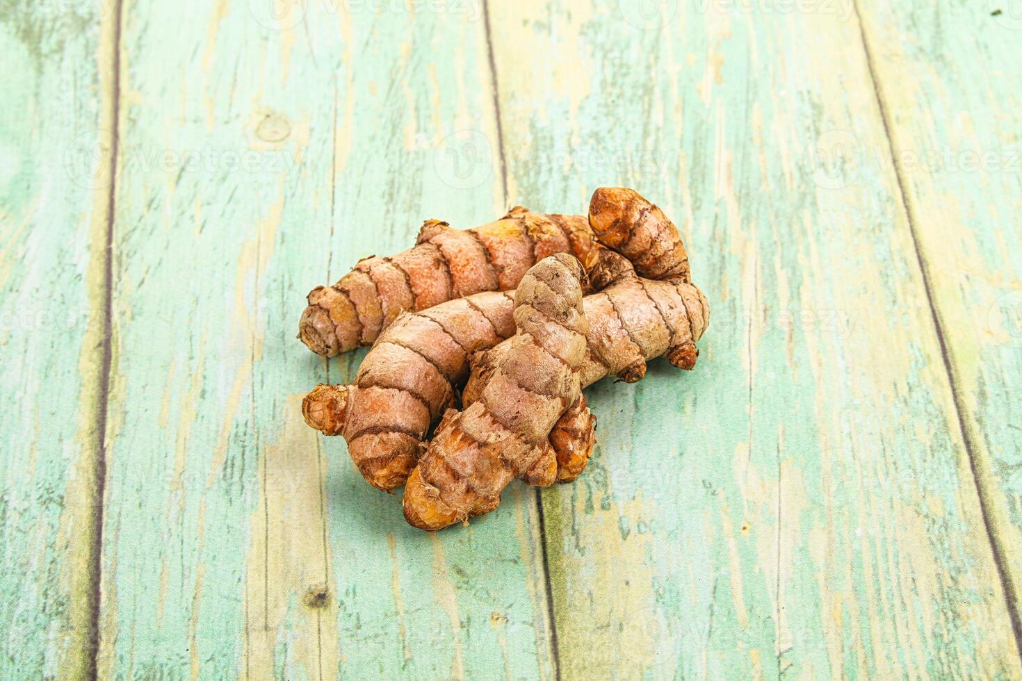 A pile of raw ginger on a wooden table photo